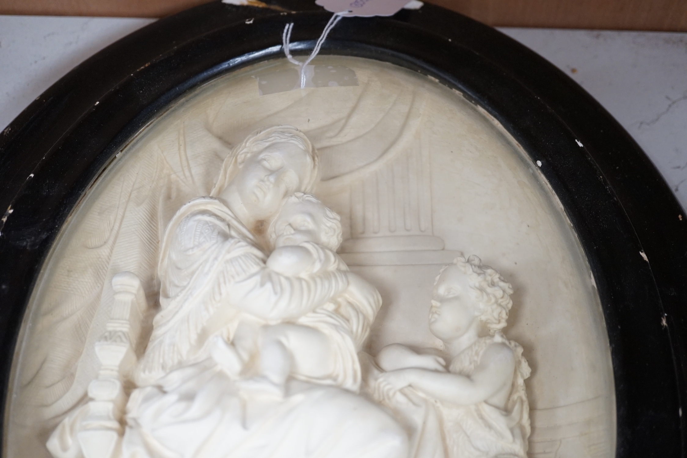 A pair of framed plaster ovals of the Madonna and Child with John the Baptist and the 'Descent from the Cross' 41x33cm